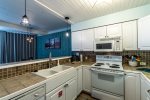 kitchen area, breakfast bar, pendant lights, tile counter tops, microwave, kitchen amenities,  wood ceiling